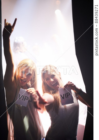 Backstage beauties. Two young women holding backstage passes at a music concert. 88439271