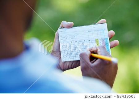 Staying below par. Rearview shot of a young golfer marking his scorecard. Staying below par. Rearview shot of a young golfer marking his scorecard. 88439505