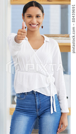 Productive and positive. Shot of a young businesswoman showing a thumbs up in a modern office. 88439691