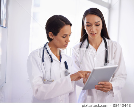 Its easier if you go in this way. Shot of a young doctor getting advice from a colleague. Its easier if you go in this way. Shot of a young doctor getting advice from a colleague. 88440448