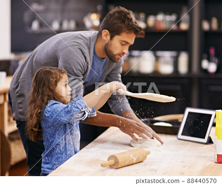 Shes got talent. Shot of a father and daughter working with pizza dough in the kitchen. 88440570