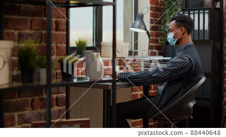 Accountant with face mask planning marketing project on laptop at company job. Office worker doing paperwork with financial statistics to create business development and growth. Tripod static shot Accountant with face mask planning marketing project on laptop at company job. Office worker doing paperwork with financial statistics to create business development and growth. Tripod static shot 88440648