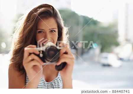 Taking pictures of everything on vacation. Cropped shot of an attractive young woman in an urban setting. Taking pictures of everything on vacation. Cropped shot of an attractive young woman in an urban setting. 88440741