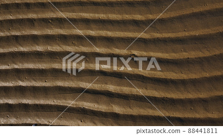 Stripes of fine sea sand on the coast. Natural background from the sand of the sea. 88441811