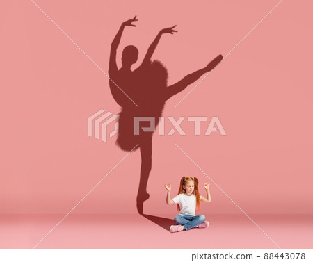 Little red-headed girl dreams of becoming a ballet dancer isolated on pink background. Sport, career and dreams concept. Collage Little red-headed girl dreams of becoming a ballet dancer isolated on pink background. Sport, career and dreams concept. Collage 88443078