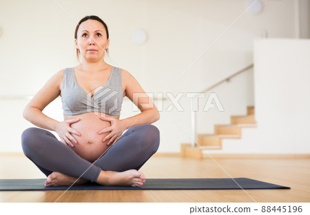 Pregnant woman is engaged in yoga. Easy Pose or Sukhasana Pregnant woman is engaged in yoga. Easy Pose or Sukhasana 88445196