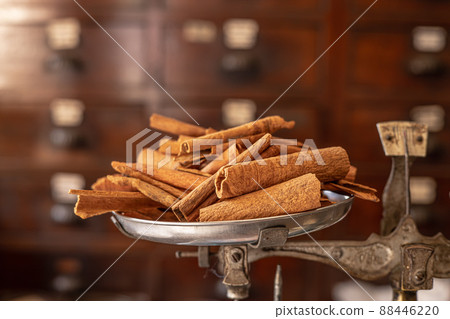 Cinamon stick roll Asian dry herb and food aroma from tree bark placed at weight scale in Chinese medicine shop. 88446220