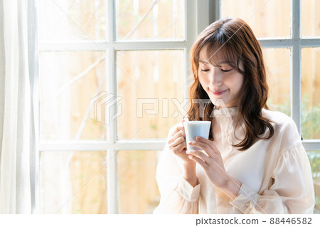 在窗口的婦女飲用的咖啡 88446582