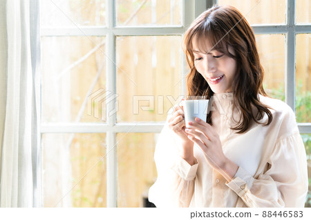 在窗口的婦女飲用的咖啡 88446583