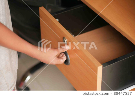 man's hand open drawer wooden in cabinet 88447537
