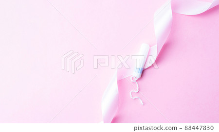 Tampon woman feminine hygiene. Pink ribbon with menstrual tampon on pink background. Menstruation feminine period. Soft tender protection for women critical days. 88447830