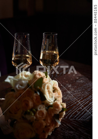 Glasses with schampanski and a bouquet of flowers, a romntychexy evening in an intimate atmosphere. Date. 88448165
