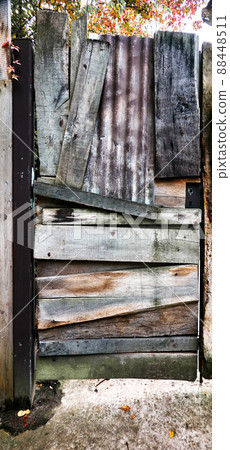 Ugly old locked door hammered together messily and crookedly from various wooden planks 88448511
