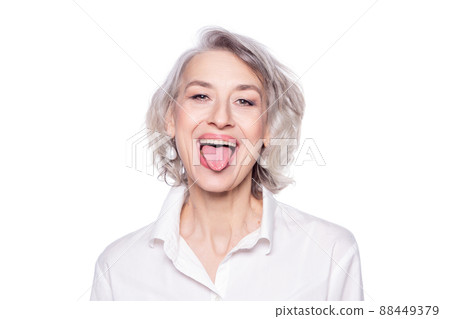 Shot of a beautiful mature woman having fun and teasing sticking out her tongue isolated on white background Shot of a beautiful mature woman having fun and teasing sticking out her tongue isolated on white background 88449379