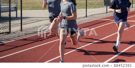 Three giels running fast on a track Three giels running fast on a track 88452391