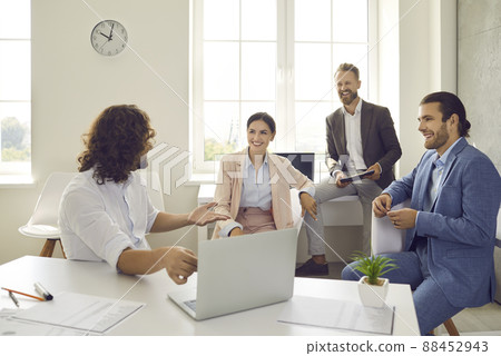 Smiling colleagues have a pleasant casual conversation at a meeting in the office. Smiling colleagues have a pleasant casual conversation at a meeting in the office. 88452943