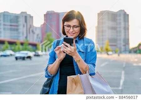 Middle aged woman using smartphone in the city Middle aged woman using smartphone in the city 88456017