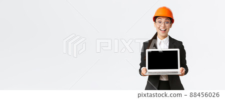 Excited happy asian female engineer, industrial manager in business suit and safety helmet showing laptop screen to investors or clients, amazed with great profit chart, introduce diagram Excited happy asian female engineer, industrial manager in business suit and safety helmet showing laptop screen to investors or clients, amazed with great profit chart, introduce diagram 88456026