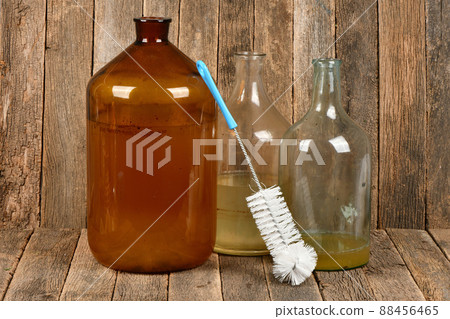 Wire brush for cleaning bottles on dark wood background Wire brush for cleaning bottles on dark wood background 88456465