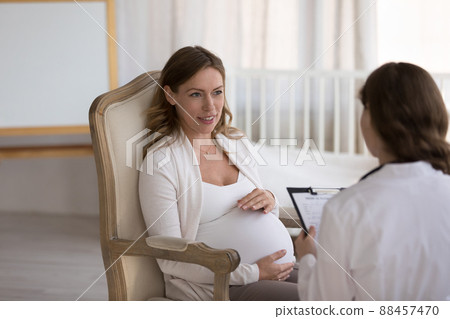 Gynecologist doctor meeting with pregnant patient, asking questions 88457470