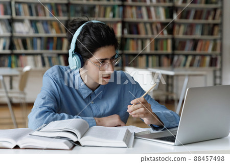 Student do schoolwork in library, make videocall talk to tutor Student do schoolwork in library, make videocall talk to tutor 88457498