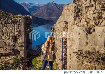 Young tourist woman enjoying a view of Kotor Bay, Montenegro. Kotor Old Town Ladder of Kotor Fortress Hiking Trail. Aerial drone view Young tourist woman enjoying a view of Kotor Bay, Montenegro. Kotor Old Town Ladder of Kotor Fortress Hiking Trail. Aerial drone view 88459014