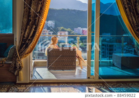 Woman on the balcony against the backdrop of mountains and city, Montenegro. life terrace pretty happiness summer home. Inspiration city romantic hotel Woman on the balcony against the backdrop of mountains and city, Montenegro. life terrace pretty happiness summer home. Inspiration city romantic hotel 88459022