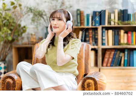 Young woman listening to music on headphones Young woman listening to music on headphones 88460702