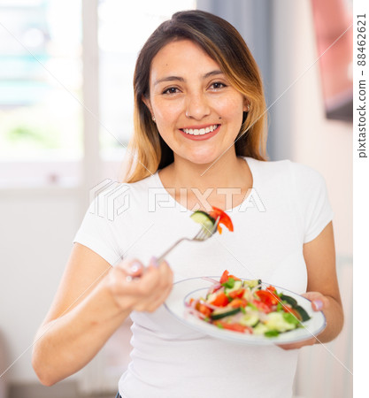 Colombian housewife eating vegetable salad at table at home 88462621