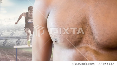 Mid section of man chest against male athlete jumping over running hurdle on sports field Mid section of man chest against male athlete jumping over running hurdle on sports field 88463532