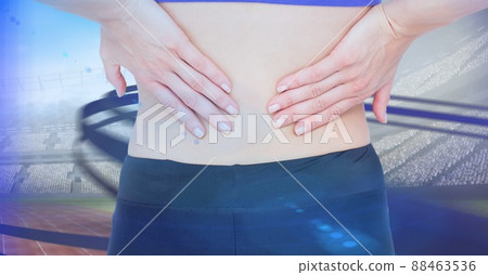 Close up of caucasian female athlete holding her injured waist over digital waves and sports field Close up of caucasian female athlete holding her injured waist over digital waves and sports field 88463536