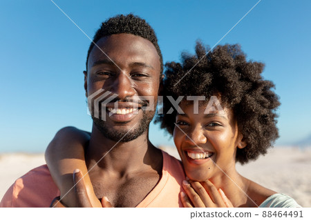 Portrait of happy african american couple enjoying summer holiday at beach Portrait of happy african american couple enjoying summer holiday at beach 88464491