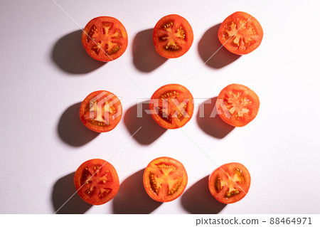 Directly above view of fresh red tomato halves arranged in a row on white background Directly above view of fresh red tomato halves arranged in a row on white background 88464971