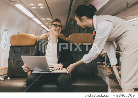 Cabin crew staff or air hostess take care service businessman passenger for comfortable during travel flight Cabin crew staff or air hostess take care service businessman passenger for comfortable during travel flight 88465709