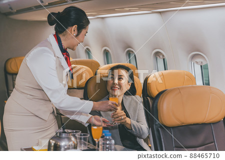 Air hostess flight cabin crew serve food and drink service passenger during travel on board. Air hostess flight cabin crew serve food and drink service passenger during travel on board. 88465710