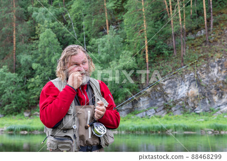 fly fishing fisherman mounts fly on fishing rod 88468299