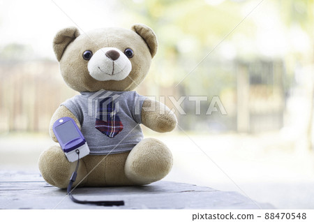 Teddy bears sitting on a wooden floor using Fingertip Pulse Oximeter to measure blood oxygen. Health concept. Teddy bears sitting on a wooden floor using Fingertip Pulse Oximeter to measure blood oxygen. Health concept. 88470548
