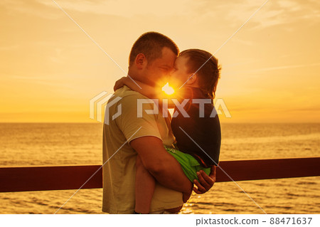 Dad and son playing at the pier on the sea at sunset Dad and son playing at the pier on the sea at sunset 88471637