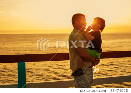 Dad and son playing at the pier on the sea at sunset Dad and son playing at the pier on the sea at sunset 88471638