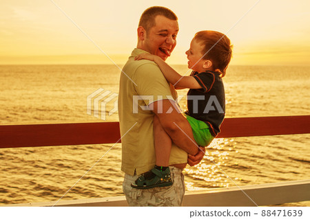 Dad and son playing at the pier on the sea at sunset Dad and son playing at the pier on the sea at sunset 88471639