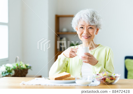 Senior woman eating breakfast Senior woman eating breakfast 88472428