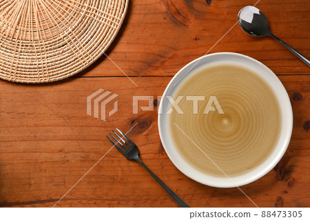Blank plate, spoon, fork, bamboo placemat on wooden dining table 88473305