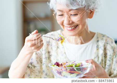 Senior woman eating salad Senior woman eating salad 88473861