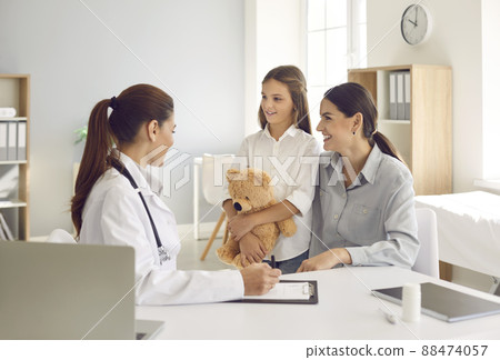 Happy mother and her little daughter talking to their family doctor at the hospital 88474057