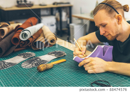 Craftsman drawing shoe last pattern creating leatherwork at studio leather workshop Craftsman drawing shoe last pattern creating leatherwork at studio leather workshop 88474576