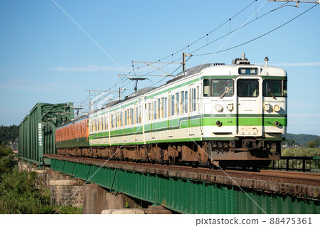 Secondary Niigata-colored 115 series crossing the iron bridge of the diversion 88475361