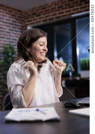 Excited enthusiastic businesswoman in workspace being motivated by salary raise. Happy positive office worker sitting at desk while celebrating successful accounting data report analysis. Excited enthusiastic businesswoman in workspace being motivated by salary raise. Happy positive office worker sitting at desk while celebrating successful accounting data report analysis. 88476842