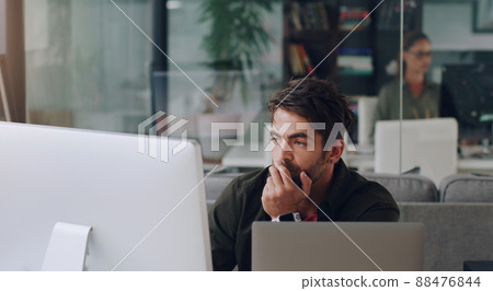 Hes got work to do. Cropped shot of a handsome young businessman working on his computer in the office. 88476844