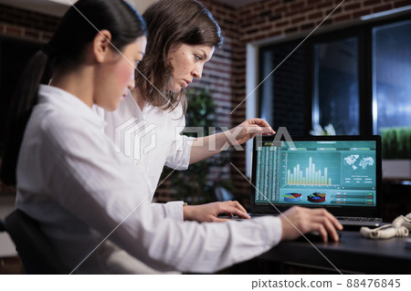 Marketing agency employees discussing about bankruptcy while analyzing financial data on laptop screen. Business company office workers sitting at desk while reviewing startup project state. 88476845