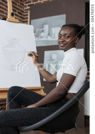 Portrait of smiling student attenting drawing class enjoying sketch lesson in creativity studio. Painter woman sketching vase model on white canvas working at graphic technique. Creative concept 88476859